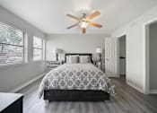 Thumbnail 12 of 15 - A bedroom with a bed, dresser, and a ceiling fan.
