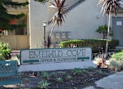 Thumbnail 1 of 5 - A sign that says Emerald Cove in front of a building.