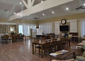 Thumbnail 2 of 5 - A spacious living room with a large wooden table and chairs.