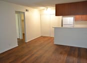 Thumbnail 3 of 5 - A room with wooden floors and white walls.