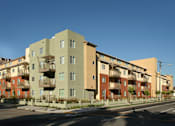 Thumbnail 2 of 2 - Apartment buildings with balconies line a street.