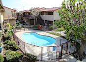 Thumbnail 18 of 37 - A pool surrounded by a fence and a tree.