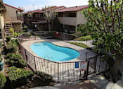Thumbnail 34 of 37 - A pool surrounded by a fence and trees.