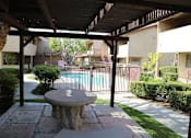 Thumbnail 28 of 37 - A patio with a table and chairs overlooking a pool.