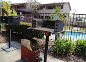 Thumbnail 29 of 37 - A red trash can with a black pole and a black grill on top of it.
