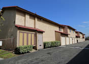 Thumbnail 14 of 37 - A long building with a red tile roof and a metal fence in front.