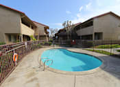 Thumbnail 17 of 37 - A small pool in a courtyard surrounded by a fence.