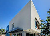 Thumbnail 2 of 77 - A modern building with a white facade and large windows.