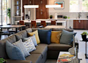 Thumbnail 48 of 77 - A living room with a grey couch and a coffee table.