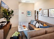 Thumbnail 50 of 77 - A living room with a brown couch and a coffee table.