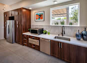 Thumbnail 53 of 77 - A modern kitchen with a refrigerator, sink, and cabinets.
