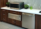 Thumbnail 57 of 77 - A modern kitchen with a microwave, oven, and dishwasher.