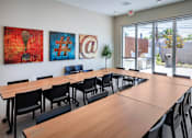 Thumbnail 49 of 77 - A conference room with a long table and chairs, and three artworks on the wall.