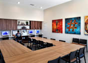 Thumbnail 51 of 77 - A conference room with a long table and chairs, and paintings on the wall.