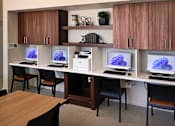 Thumbnail 35 of 77 - A room with a desk and chairs with a computer on it.