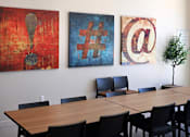 Thumbnail 43 of 77 - A conference room with a long table and three paintings on the wall.