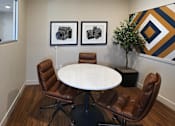 Thumbnail 40 of 77 - A conference room with a white table and brown chairs.