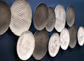 Thumbnail 37 of 77 - A series of circular objects with a pattern of lines are displayed against a dark background.