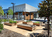 Thumbnail 14 of 77 - A garden with raised beds in front of a building.