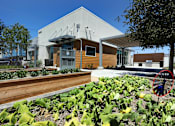 Thumbnail 1 of 77 - A building with a brown roof and a white wall with a black awning.