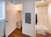 Thumbnail 63 of 77 - A bathroom with a white door, a white towel rack, and a white shower curtain.