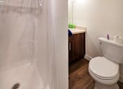 Thumbnail 69 of 77 - A white toilet in a bathroom with a white shower curtain.
