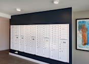 Thumbnail 66 of 77 - A wall of white mailboxes is mounted on a black wall.