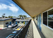 Thumbnail 1 of 21 - A parking lot with a white car and a blue building.