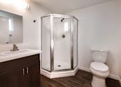 Thumbnail 11 of 21 - A bathroom with a toilet, sink, and shower.