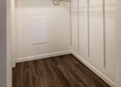 Thumbnail 9 of 21 - A walk-in closet with a white door and a white wall.