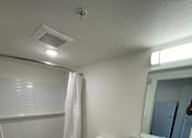 Thumbnail 10 of 15 - A white bathroom with a toilet, sink, and shower.