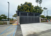 Thumbnail 5 of 15 - A black gate with a yellow line in front of a building.