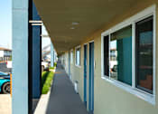 Thumbnail 36 of 37 - A long, narrow building with a blue trim and white walls.