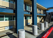 Thumbnail 23 of 37 - A large blue sculpture stands in front of a building with a red line on the ground.
