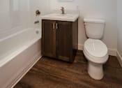 Thumbnail 16 of 37 - A white toilet sits next to a sink in a bathroom.