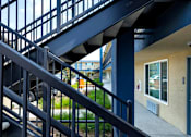 Thumbnail 10 of 37 - A staircase with a metal railing and steps leading to a door.