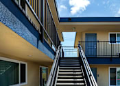 Thumbnail 11 of 37 - A staircase with a metal railing leads up to a balcony.