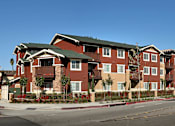 Thumbnail 1 of 2 - Apartment building with red brick and green roofs.