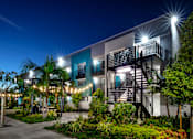 Thumbnail 98 of 116 - A modern building with a staircase and lights on the trees.
