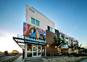 Thumbnail 114 of 116 - A modern building with a colorful mural on the side and the name "Estrella Springs" on the front.