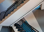 Thumbnail 107 of 116 - A staircase with a metal railing and a wooden handrail.
