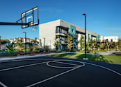 Thumbnail 115 of 116 - A basketball court is located in front of a modern building.