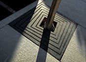 Thumbnail 78 of 116 - A square-shaped metal grate with a tree trunk in the center.