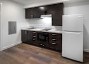 Thumbnail 86 of 116 - A kitchen with brown cabinets and a white fridge.