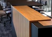 Thumbnail 72 of 116 - A wooden desk with a black base and a wooden top.