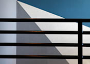 Thumbnail 75 of 116 - A staircase with a metal railing and a wall with a blue and white design.