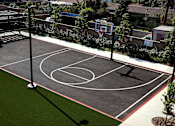 Thumbnail 53 of 116 - A basketball court with a green grass area in the middle.