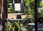 Thumbnail 41 of 116 - A table and chairs are set up under a canopy in a garden.