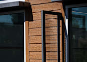 Thumbnail 40 of 116 - A wooden fence with a black metal grate in the middle.