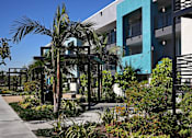 Thumbnail 37 of 116 - A modern building with a blue and white exterior and a garden in front.
